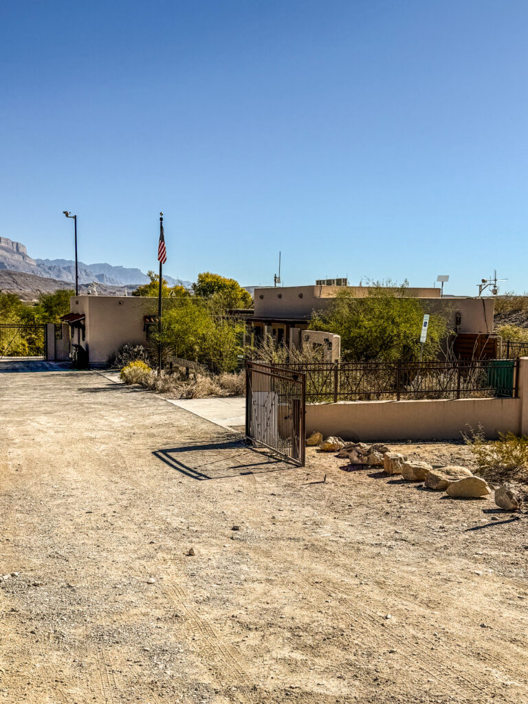 Entrance to the Boquillas Crossing, featuring a gated area with desert surroundings and a clear blue sky.